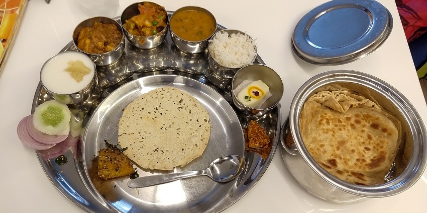 Indore thali is served at Ajab Gajab Restaurant in Limbodi, which features various traditional dishes.