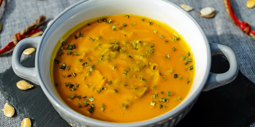 A mouthwatering view of a white bowl served with a cooked dish sitting on a table.