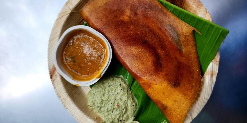 Image of Dosa served on a plate with chutney on the side - best food to eat in Kerala