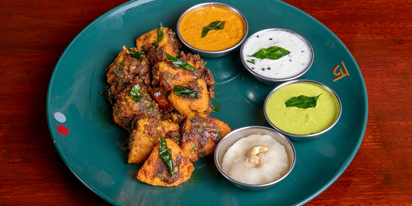 Image of delicious Idli served on a plate with colourful chutney on the side