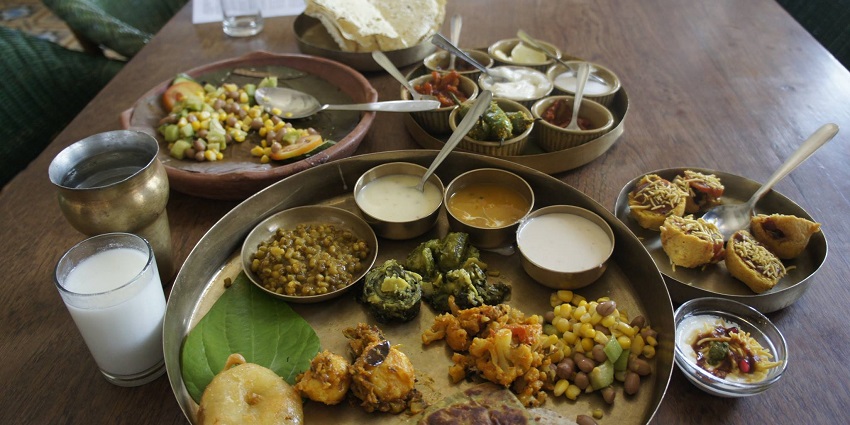 A traditional Gujarati thali served with a variety of dishes, near Jalaram Temple.