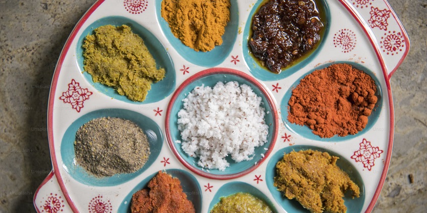 An assorted plate full of spices, traditional dishes, drinks, Thai food, and other ingredients