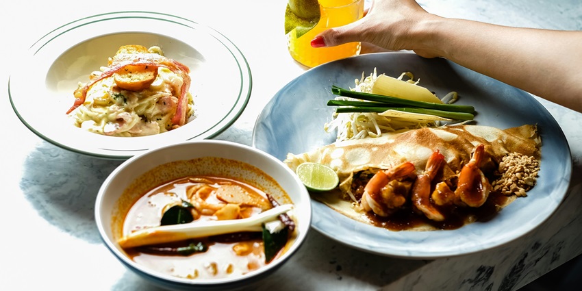 a mouthwatering view of a table served with different dishes and glass full of juice.