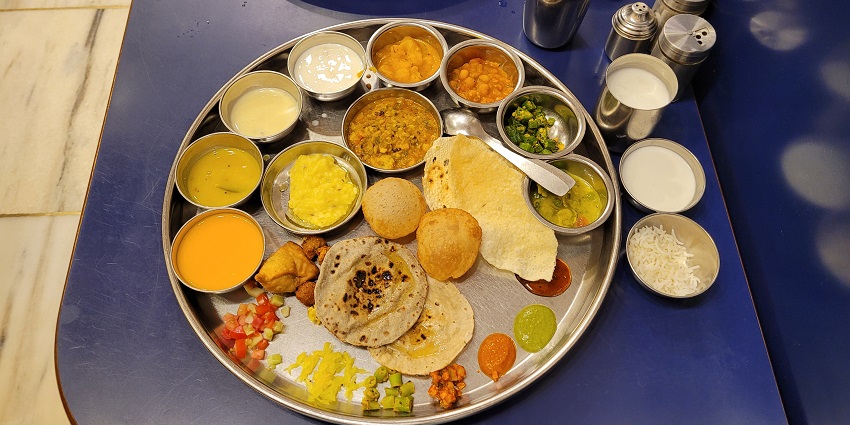 Gujarati thali with traditional dishes, showcasing vibrant flavours, served at a restaurant near Watson Museum.