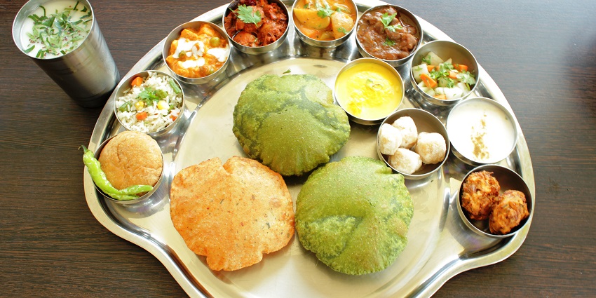 Indian dishes arranged on a table showcasing a variety of traditional curries, rice, and bread