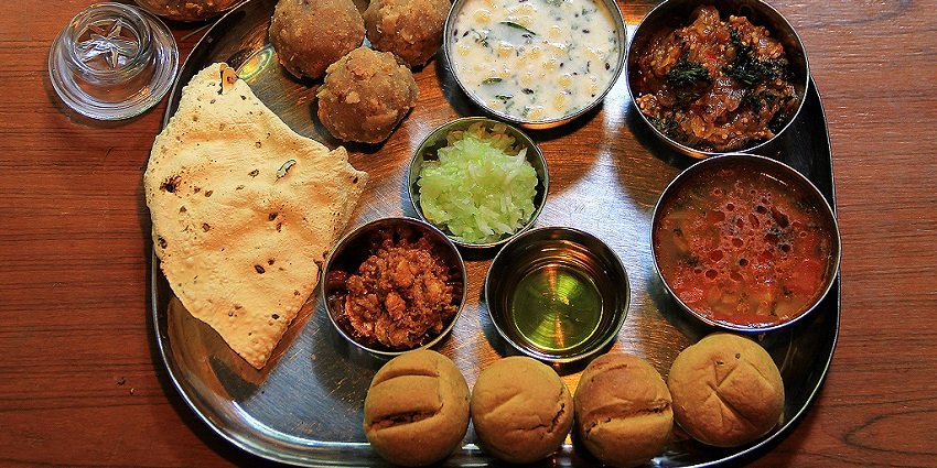 Dal baati churma served on a plate, ideal for visitors who wish to enjoy local flavours.