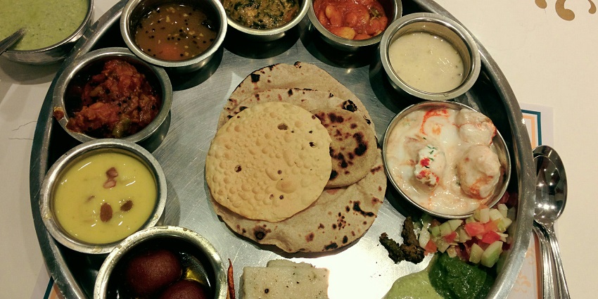 Traditional and world-famous North Indian thali served on a table of a restaurant.