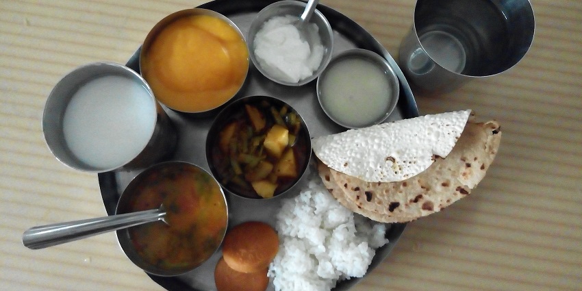 Savour a delicious plate filled with regional Gujarati delicacies at a restaurant near the Sarangpur Temple