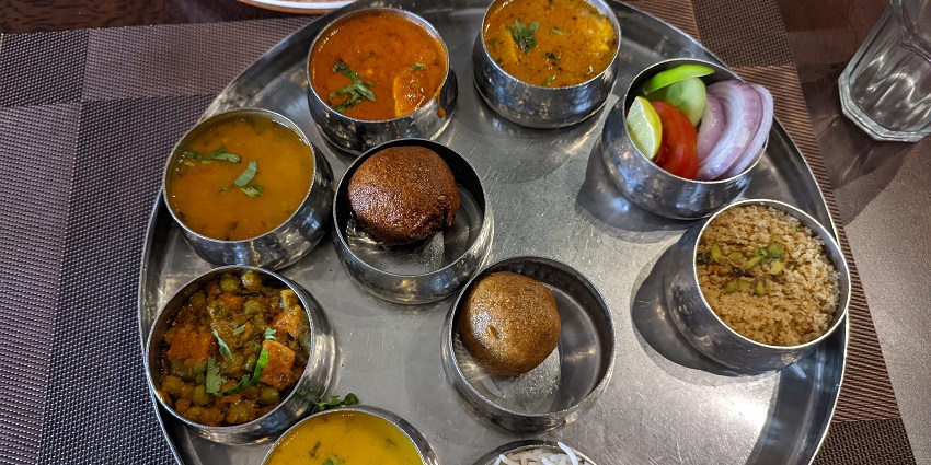 A popular Marwari thali with different courses such as curries, vegetables, and bread.