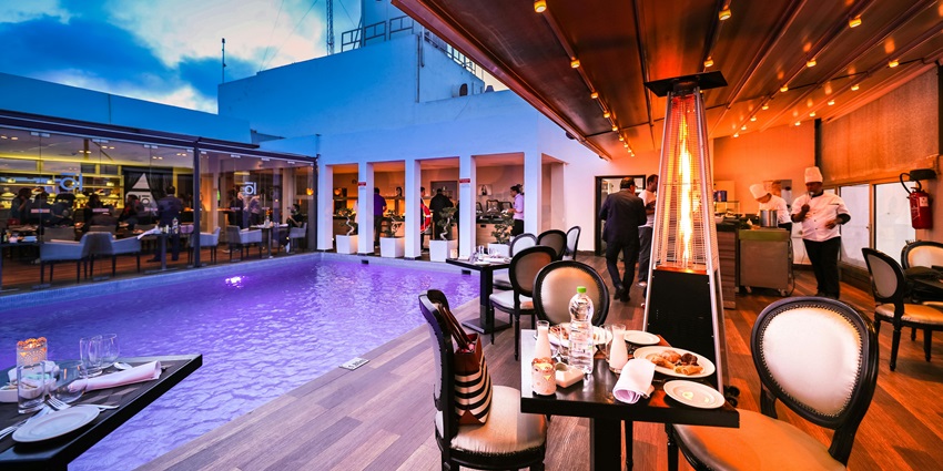 Chic dining area by the pool, perfect for enjoying meals in a relaxing, elegant setting.