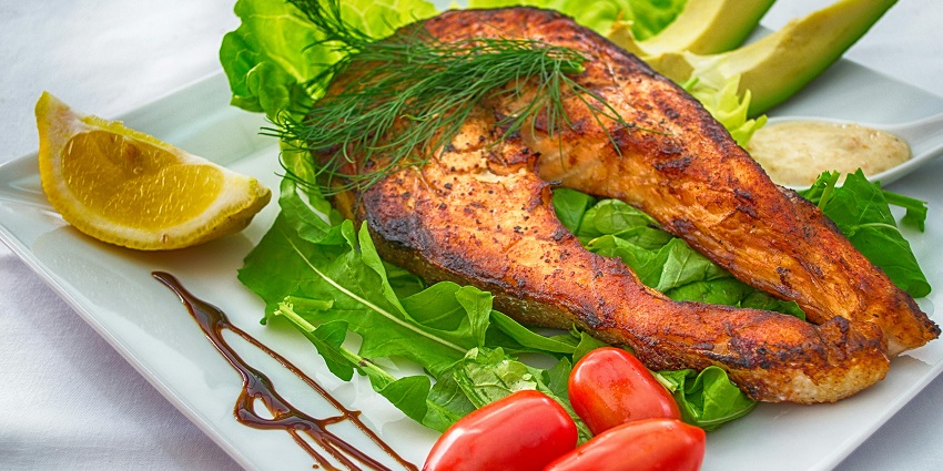 Image of delicious looking fish and lettuce, lemon one the side and few vegetable
