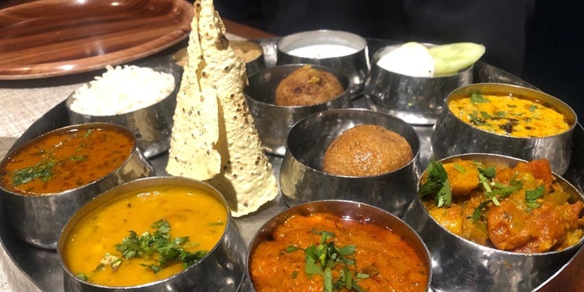 A traditional Rajasthani thali featuring a variety of dishes served in small bowls on a plate