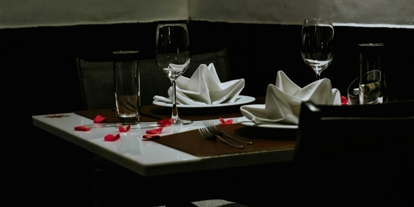 Romantic table for two adorned with wine glasses, perfect for a cosy dining experience.