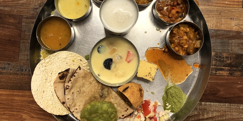 A variety of Rajasthani delicacies served on a plate - best food one can try in Rajasthan