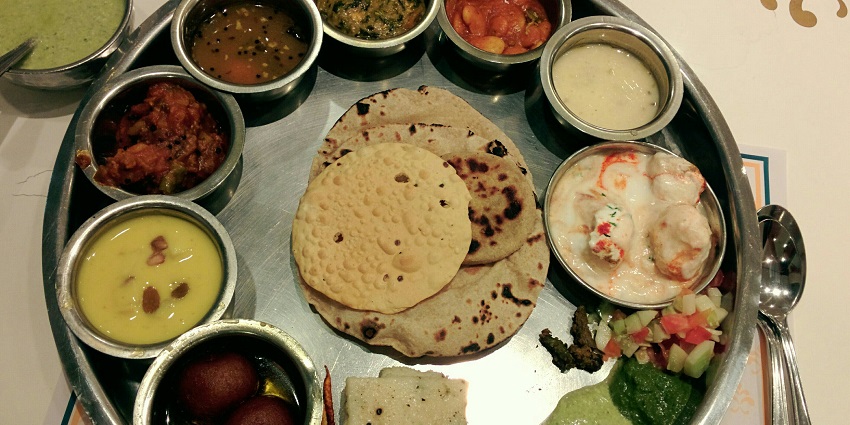 A mouth-watering view of a plate served with different food items and flatbreads.