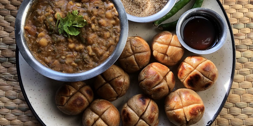 An appetizing serving of Dal Baati Churma, highlighting the golden Baati, flavorful Dal, and sweet Churma