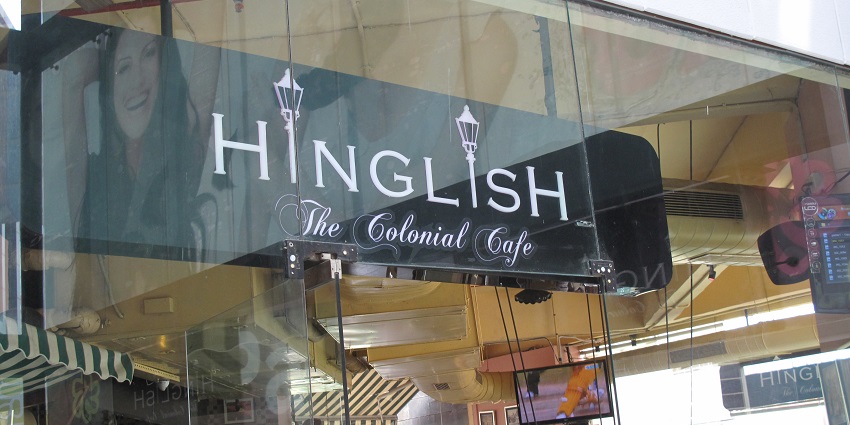 A picture of a cafe in Delhi taken from outside with people enjoying their meals inside