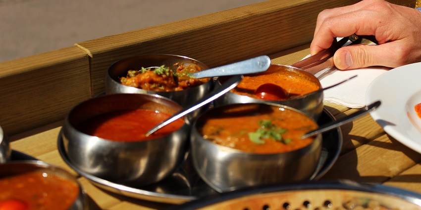 A picture of a full-fledged north Indian meal served on a table at a restaurant near Siri Fort