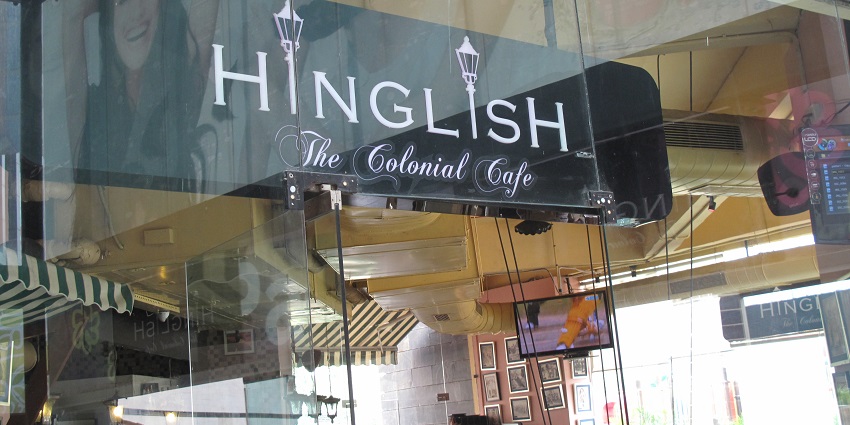 A picture of a cafe in Delhi taken from outside with people enjoying their meals inside