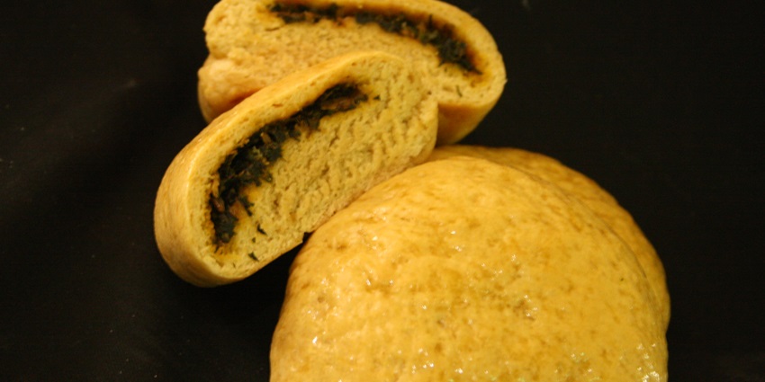 A plate of Siddu, a traditional Himachali steamed bread, served with ghee.