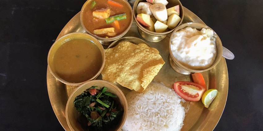 Traditional Nepali dal bhat tarkari served on a plate, featuring rice, lentils, and vegetables.