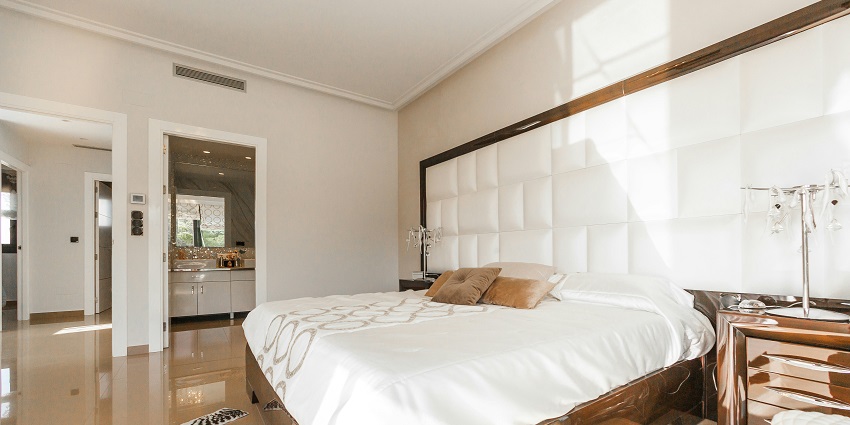 Cosy bedroom with a wooden bed frame, white linens, and a matching wooden nightstand