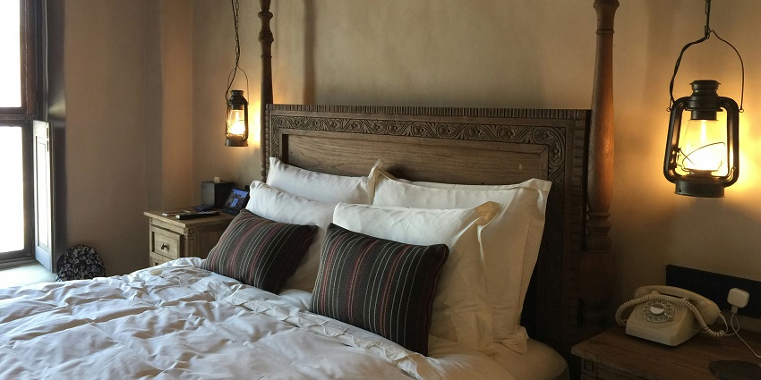 A stunning view of a bedroom with a brown bed lined with white sheets and pillows.