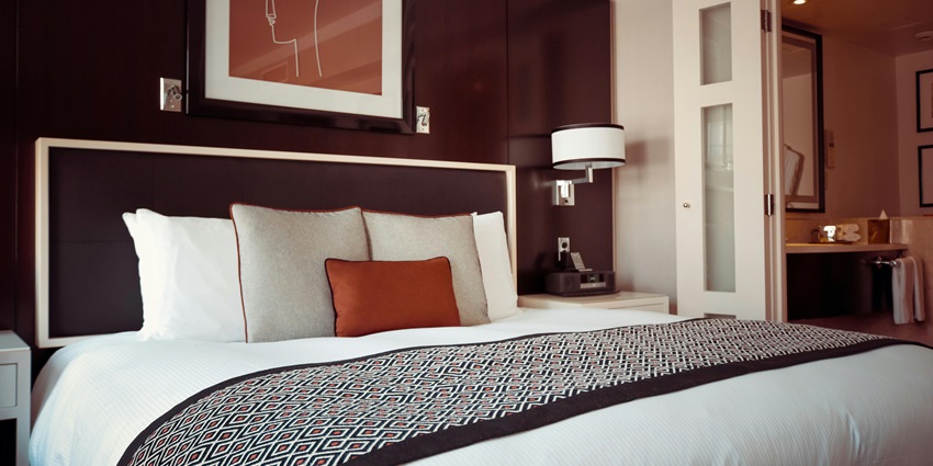 A hotel room black and grey bedspread on bed and pillow - available budget hotels around Mahipalpur