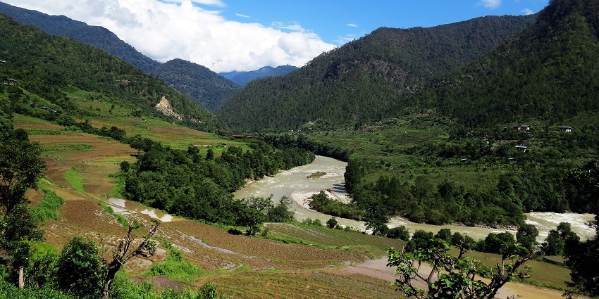 The tranquil landscapes of Bhutan with a river flowing down a beautiful hill