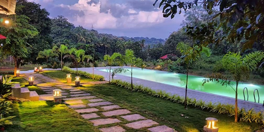 The resort with a pool and foliage offering perfect amenities to stay for visitors.