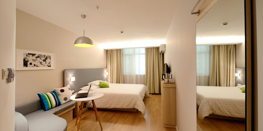 A cosy bedroom featuring a neatly made bed, stylish decor, and warm lighting