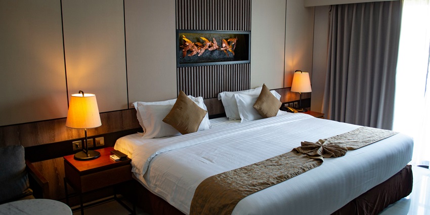 Image of a hotel room with lights, bed, pillows and nice decorations to stay