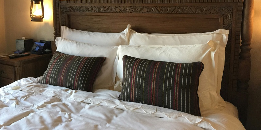 A breathtaking view of a hotel room with bed lined with white bedsheet and pillow.
