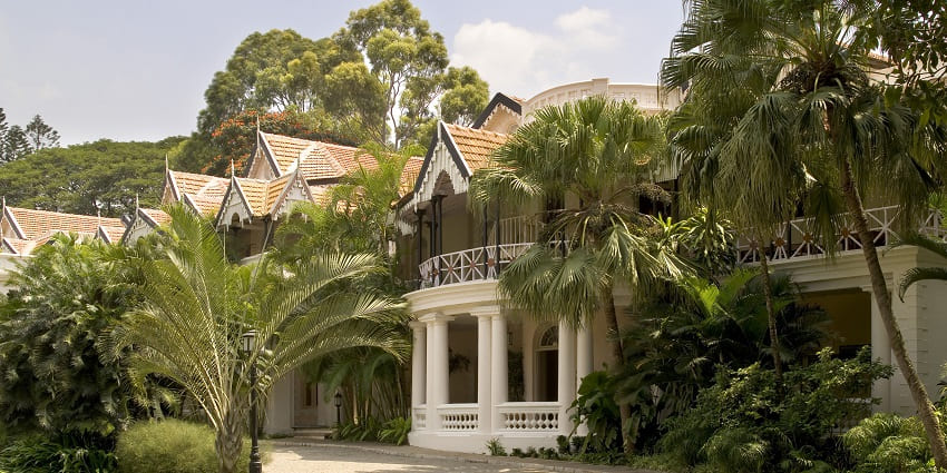 A breathtaking view of a hotel in Bangalore surrounded by lush greenery during the day.
