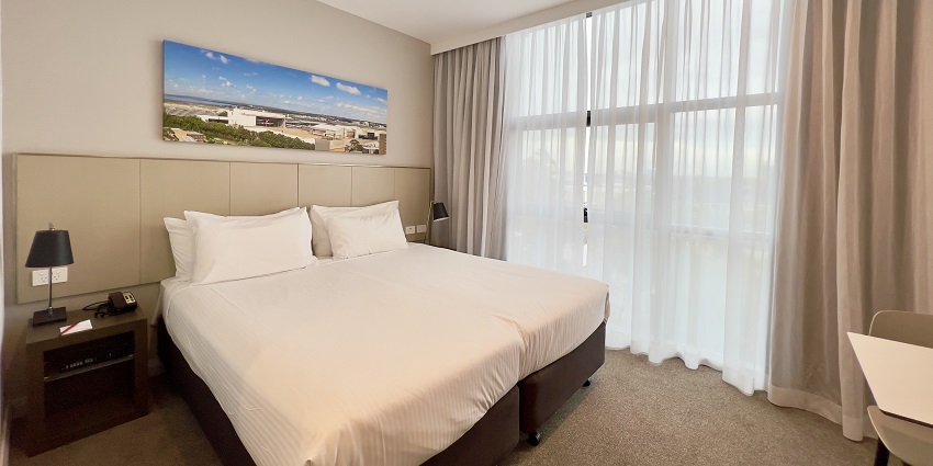 Cozy hotel room with neatly arranged furniture, inviting decor, and comfortable bedding.