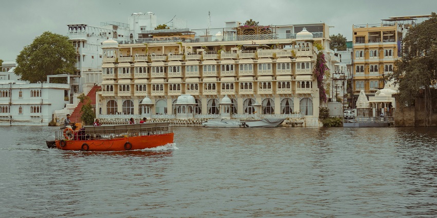 A breathtaking view of hotel with a stunning lake in the foreground during the daytime.
