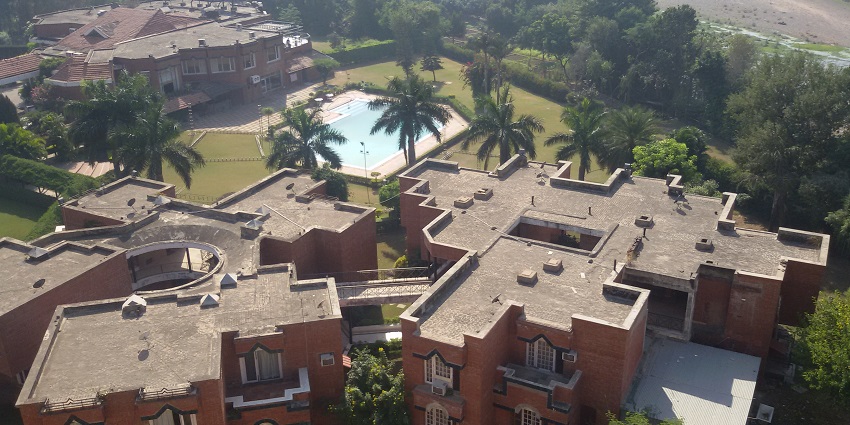 Top view with buildings, one pool, and a lush lawn of one of the hotels in India.