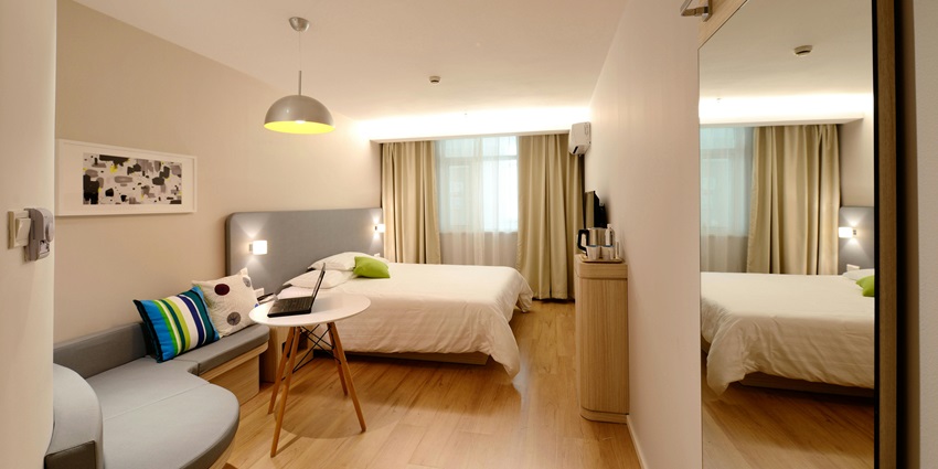 A picture of a hotel room with a bed and side table in place, creating a cosy ambience