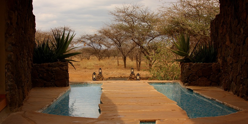 A lodge near Narsinghgarh Wildlife Sanctuary featuring a spacious deck with comfortable seating and stylish furnishings.