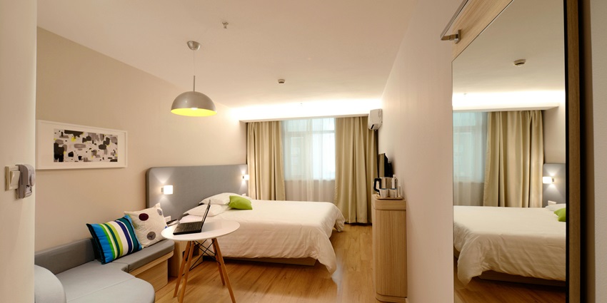 Inviting hotel room setup with soft lighting and comfortable bedding for a restful night.
