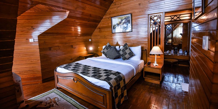 A spacious, elegant hotel premium suite with a large bed, seating area, and modern decor.