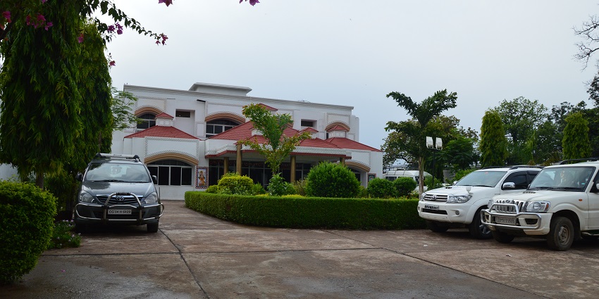 Exterior view of Ram Durbar Hotel in Satna Road, Chitrakoot, with green surroundings.