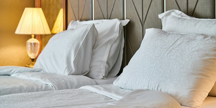 A simple image featuring a hotel room with a cosy bed near Harshnath Temple.