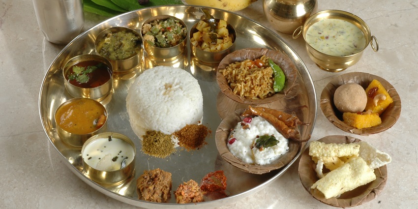 A mouth-watering view of an Andhra Pradesh thali with a glass of water and banana.