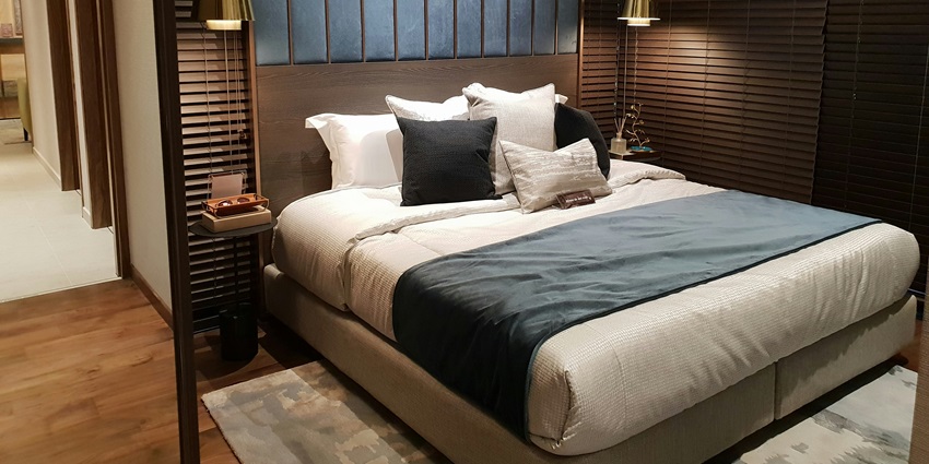 A view of a stunning bedroom with a bed lined with white sheets and a comforter.