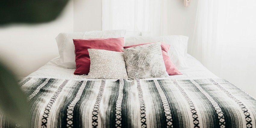 An enchanting view of a bedroom with a bed lined with white sheets and pillows on it.