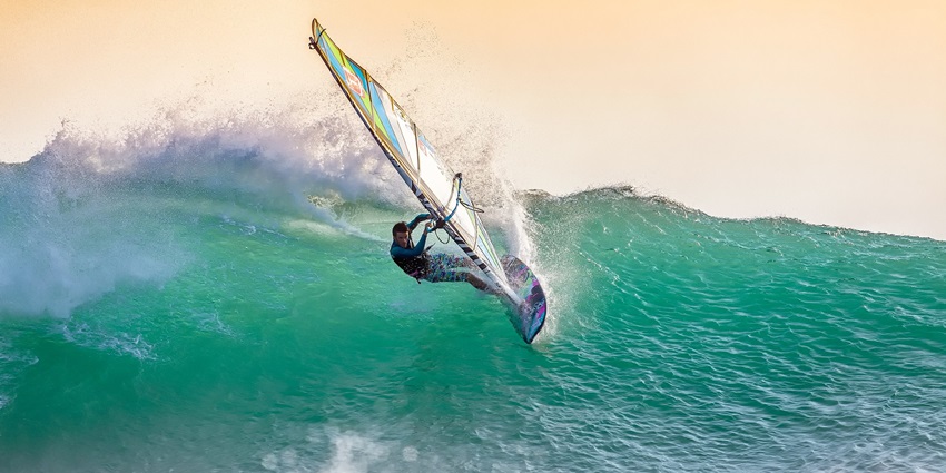 Try windsurfing which is a combination of surfing and sailing adventure activities.