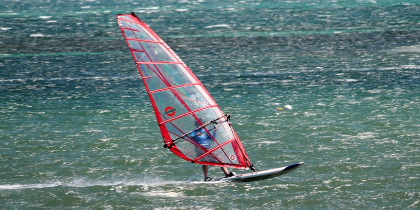 Picturesque view of a tourist windsurfing, one of the must try water sport in south Goa