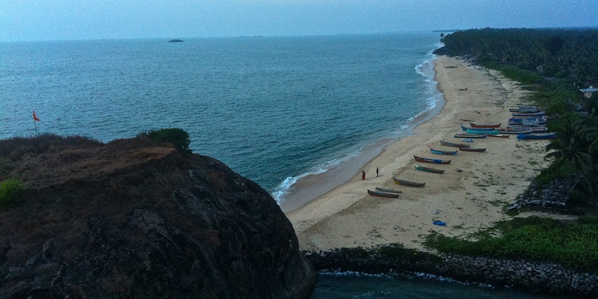 Yana Beach's rocky shoreline is surrounded by lush greenery and rough terrain