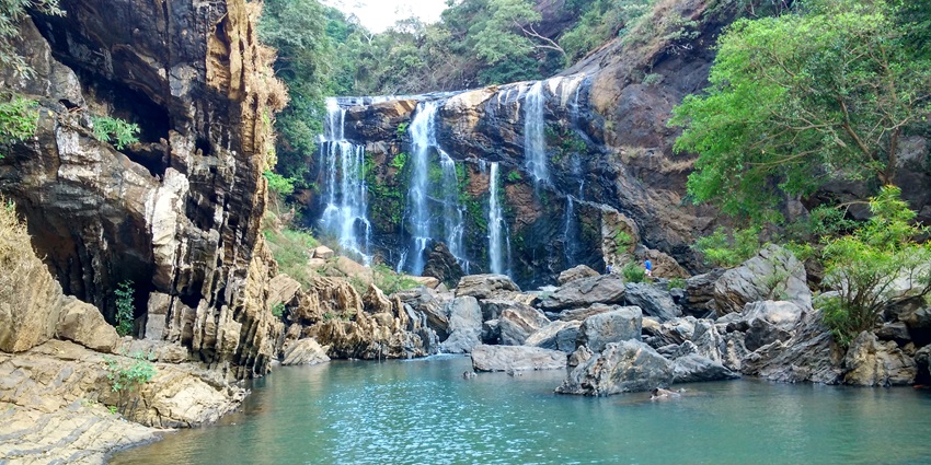 The breathtaking Sathodi Waterfalls in Yellapur surrounded by lush green vegetation.